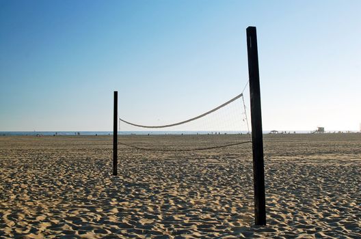 beach volleyball net in sand near ocean