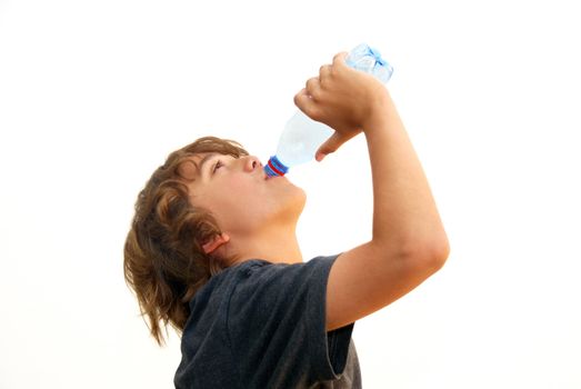 Teenage boy drinking water from a plastic bottle isolated on white background.