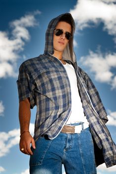 Young man urban fashion portrait over sky background