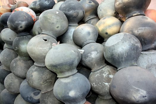 A background of clay pots used for keeping water cool, a traditional method in India.