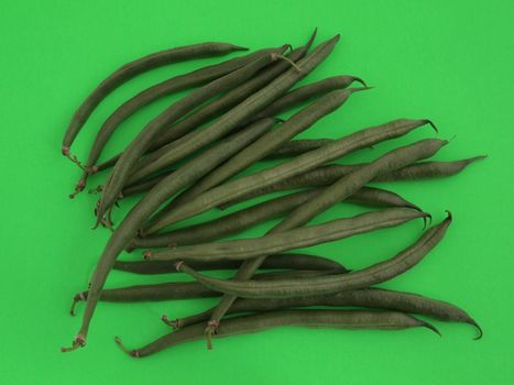 Closeup of organic runner beans on a green background.