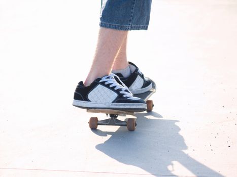 Cut out view of a skateboarders legs riding a board