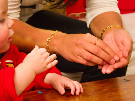 Mothers hands showing baby how to  do something