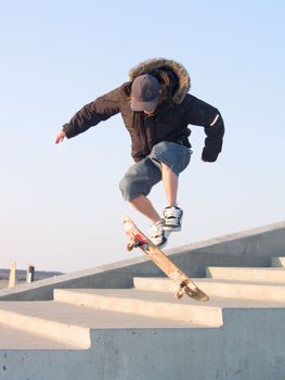 Young teenage guy doing a stunt with his skate board