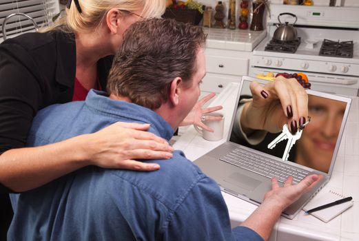 Couple In Kitchen Using Laptop with Keys Coming Through the Screen.