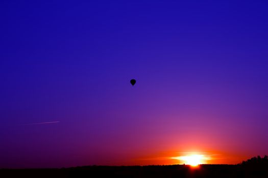 Sunset over the forest. Flying a balloon and aircraft.