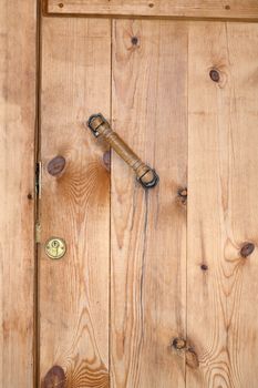Nice wooden background. Closed yellow barn door with lock and handle