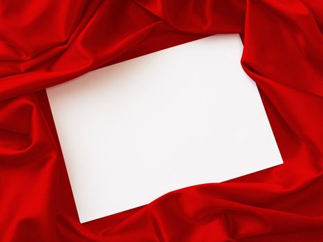 blank invitation card over the red fabric 