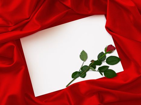 invitation cards and a red rose in the middle of a red cloth 