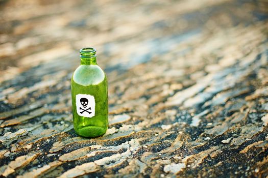 Green glass bottle from a poison on the ground