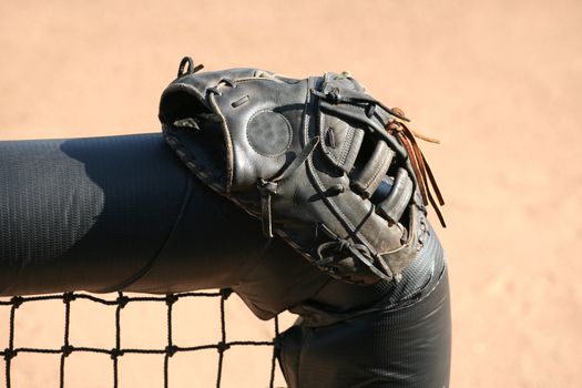 Baseball or softball glove resting on a dugout fence