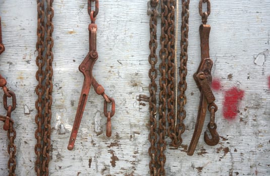 Abstract chain hanging over a weathered piece of wood or fence