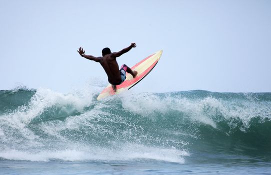 Surfer in ocean on sunset. Bali. Indonesia