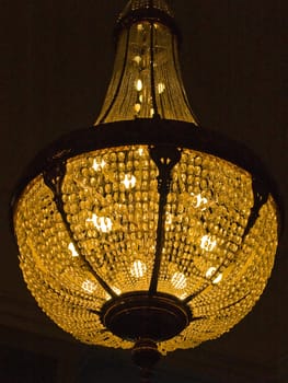 Classical Style Old Beautiful Crystal Chandelier glowing in darkness