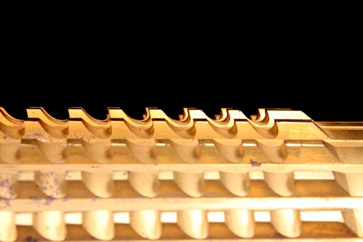 The pattern of grooves on a golden metallic industrial broach.