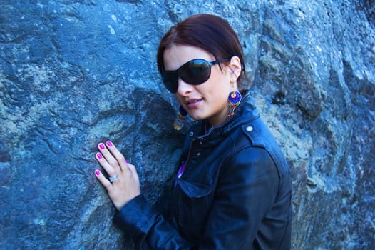 Attractive woman in sunglasses near the rock