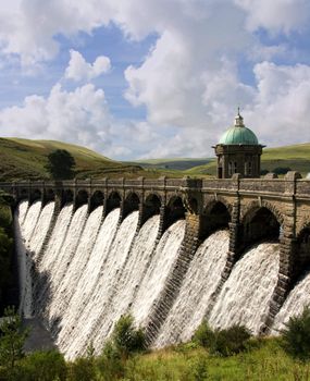 Water overflowing a dam, Craig Goch reservoir, Elan Valley Wales.