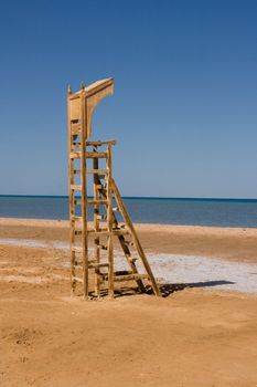 Empty baywatch seat on the beach. (lifeguard chair)