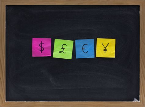 dollar, pound, euro and yen currency symbols presented with crumpled sticky notes posted on a blackboard with eraser smudges