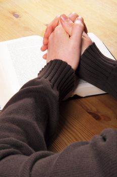 praying hands and book showing christian religion concept