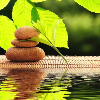 zen stones and water reflection showing spa concept