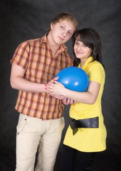 Young pair holds on hands a balloon as the baby