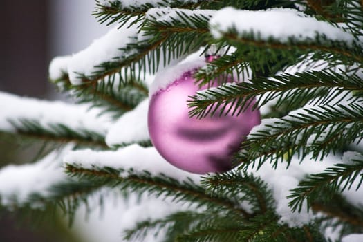 Branches of decorated christmas tree outside in the snow