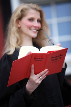 Law book with law student or lawyer. In the foreground a red code can be seen in the background, the young lawyer or law student-
