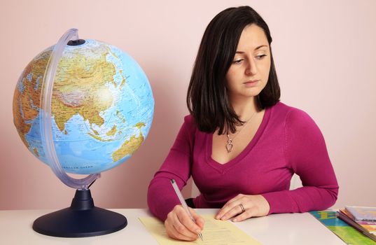 Teacher at her desk with the globe and books