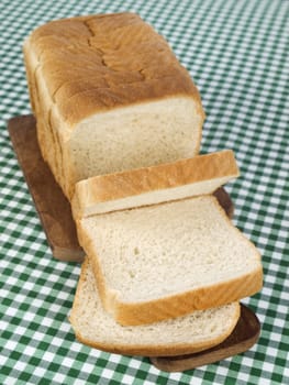 A sliced loaf of bread served on a wooden cutting board.