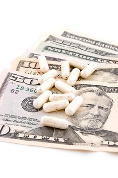 Dollars and pills isolated on white