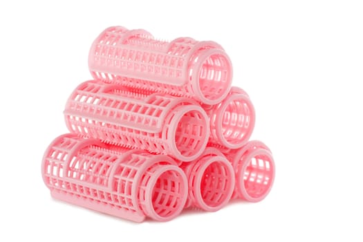 A stack of pink hair rollers isolated over white