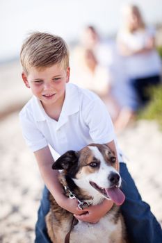 Handsome Young Boy Playing with His Dog at the Beach.
