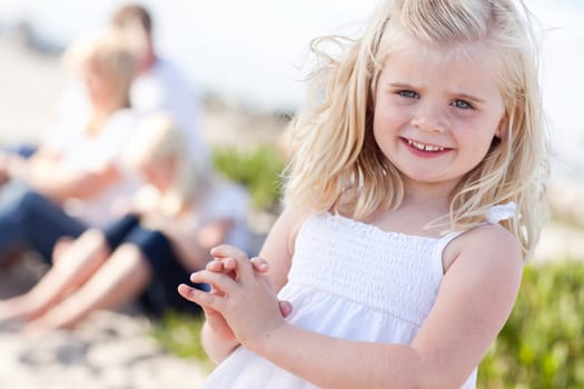 Adorable Little Blonde Girl Having Fun At the Beach with Her Family.