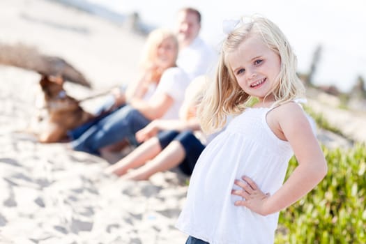 Adorable Little Blonde Girl Having Fun At the Beach with Her Family.