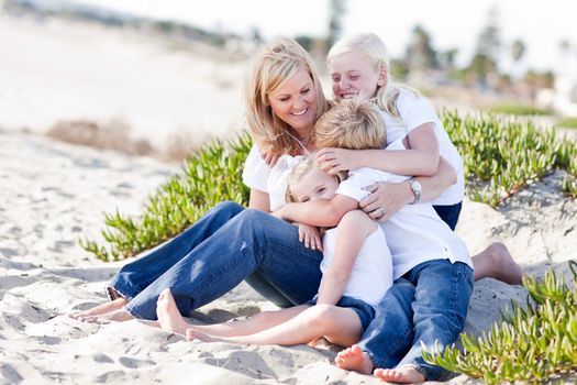 Attractive Mom Having Fun with Her Cute Children at The Beach.