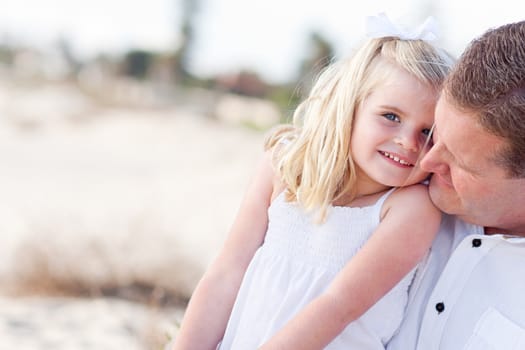 Cute Daughter Cuddles up with Her Handsome Dad at the Beach.