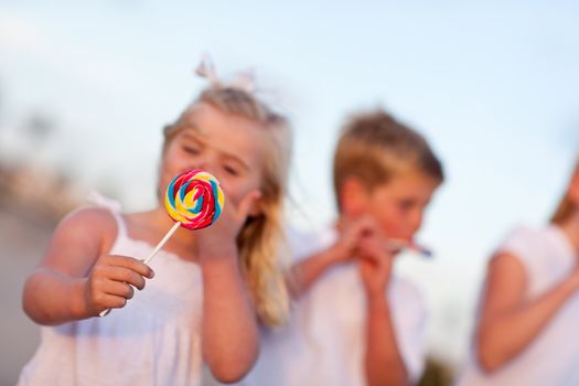 Cute Brother and Sisters Enjoying Their Lollipops at the Beach - Focus is on the Lollipop.