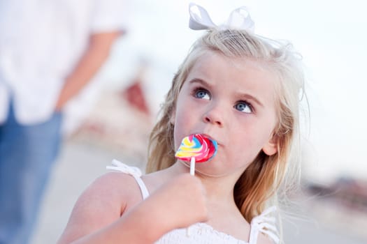 Adorable Little Girl Enjoying Her Lollipop Outside at the Beach.