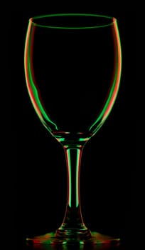 transparent colored empty wine glass, isolated on black