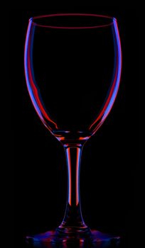 transparent colored empty wine glass, isolated on black