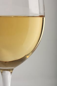 Close-up of a white wine glass over gray background
