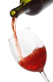 Pouring red wine into a glass isolated on white