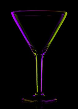 transparent colored empty martini glass, isolated on black