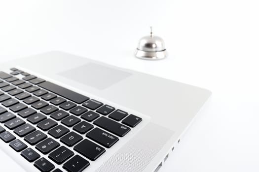 Side view cropped aluminum laptop and a silver bell