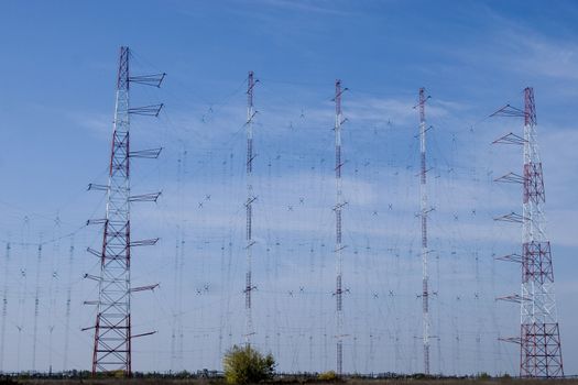 blue sky setting behind a row of electricity pylons