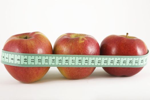 three red apple and green measurement tape, diet and healthy life concept