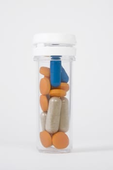 blue, orange and brown pills in a bottle