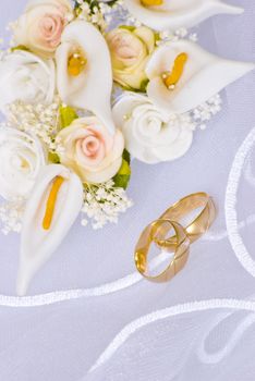 wedding rings and flowers decorations over bridal veil