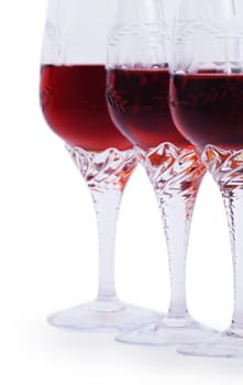Three glasses of red wine isolated on a white background Focus is on the third glass. Hand made clipping path inside